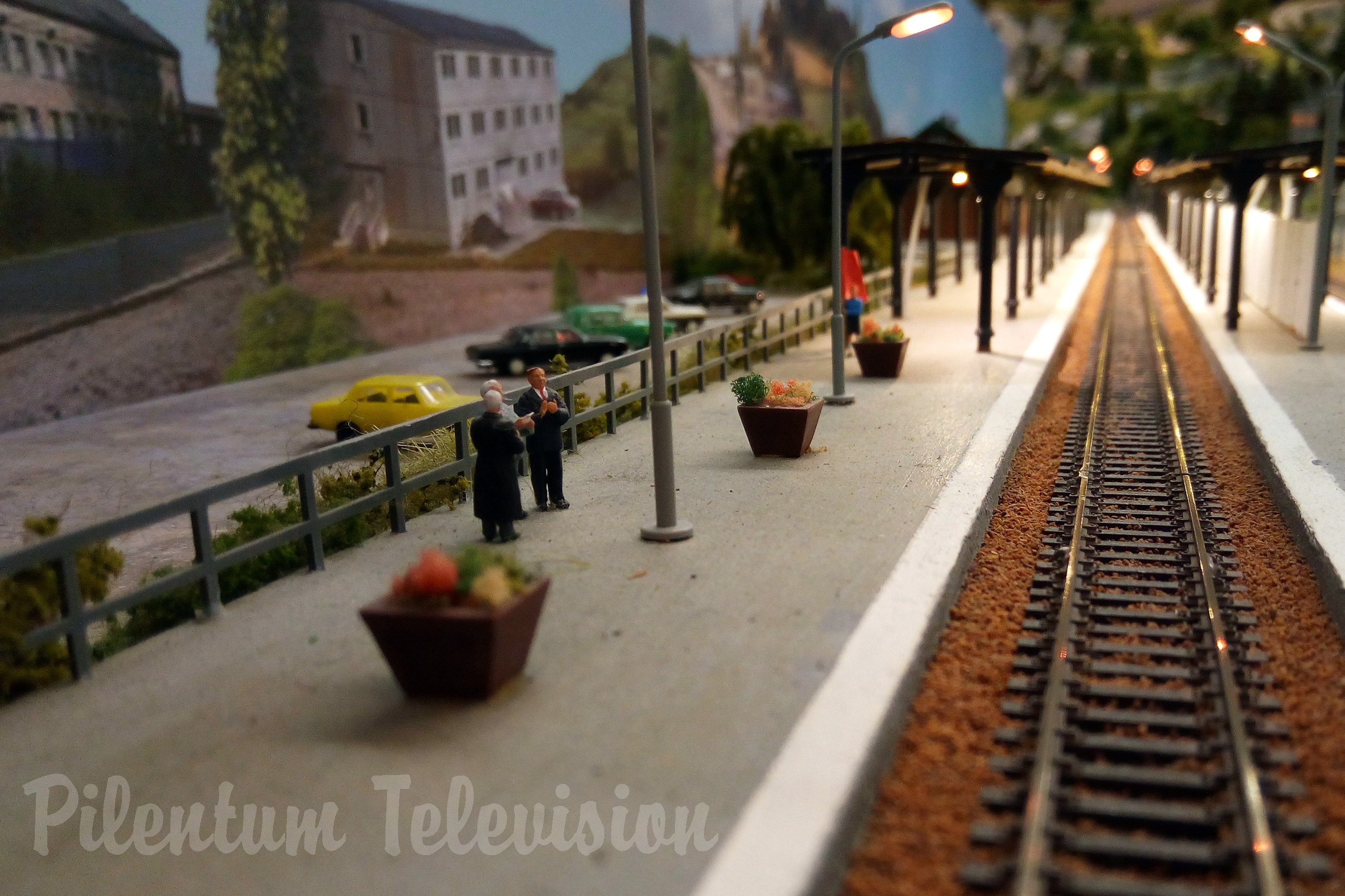 Model trains in action on a TT scale model railway layout with diesel and steam locomotives